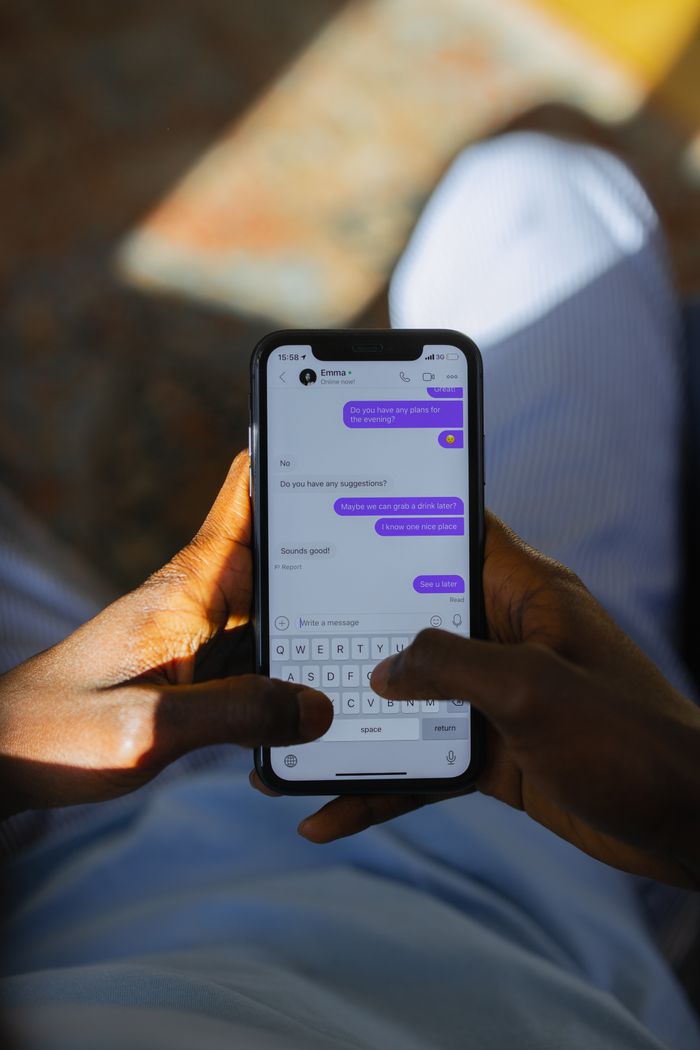 Close-up of person texting on smartphone with focus on screen chats.